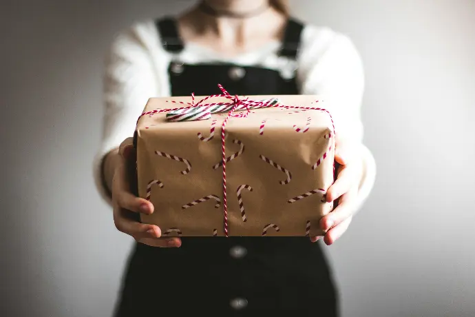 person showing brown gift box